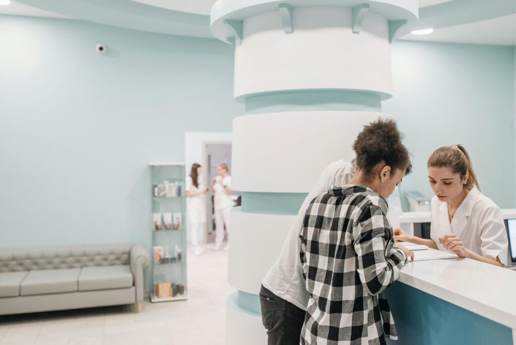 pexels-photo-7108325-7108325 Healthcare professionals assisting at a modern clinic reception desk.