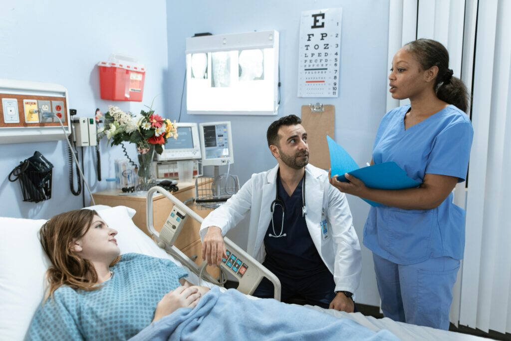 pexels-photo-6129681-6129681 Doctors and nurse discussing patient's treatment in a hospital room.